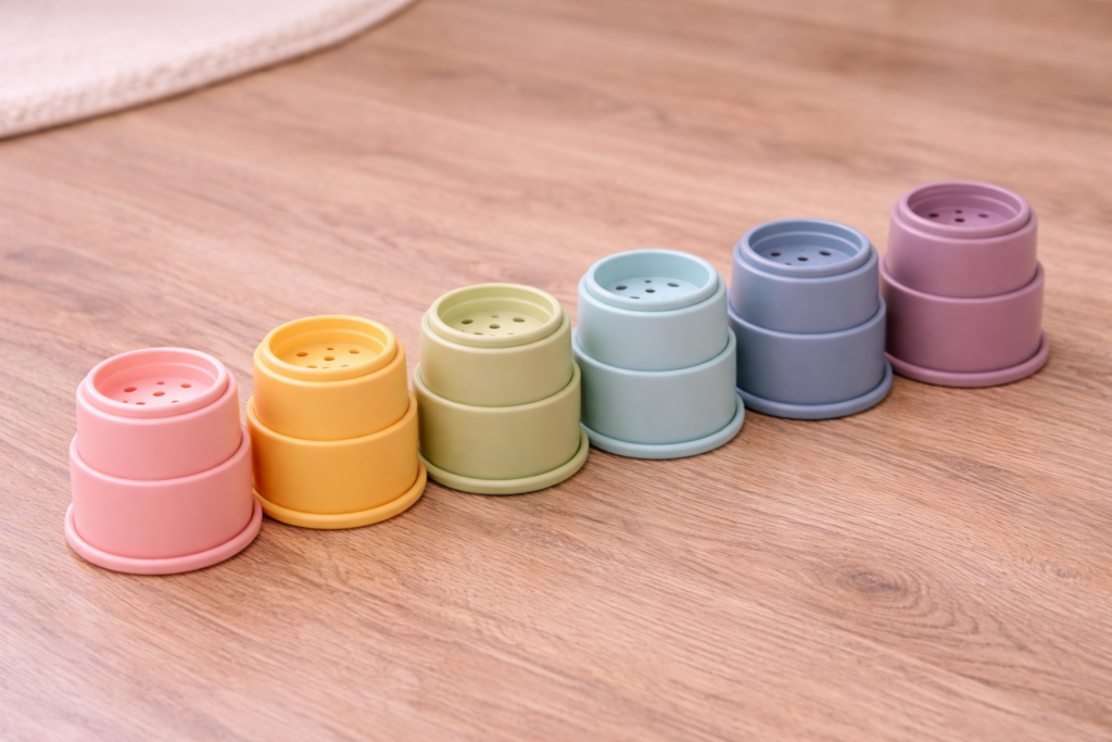 Stacking cups arranged in rainbow order on wooden floor